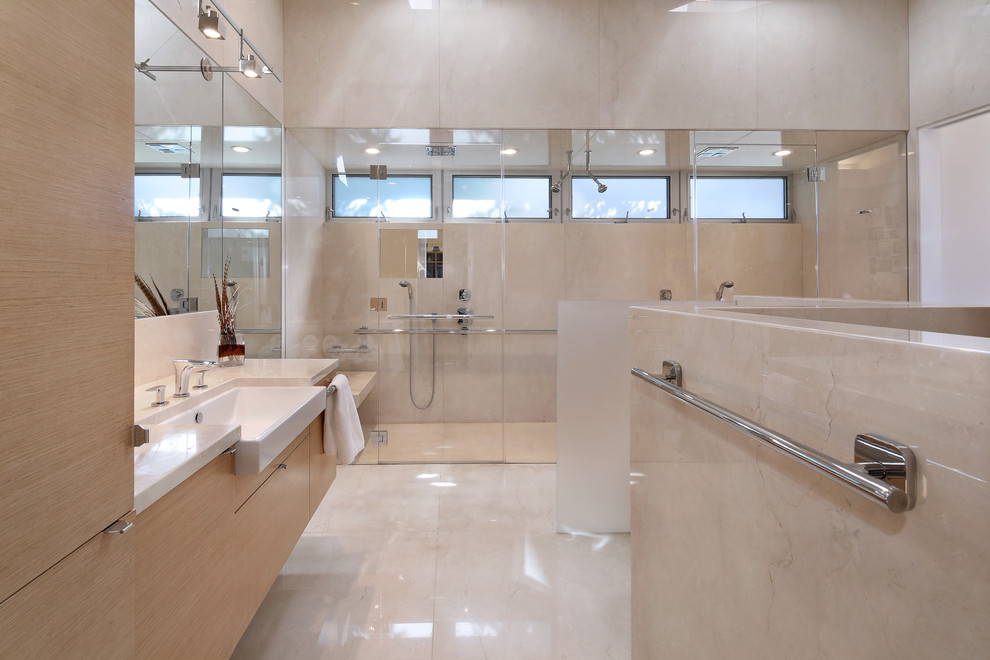 Immagine di una stanza da bagno con doccia minimal con ante lisce, ante in legno chiaro, doccia alcova, pareti beige, lavabo da incasso, pavimento beige e porta doccia a battente