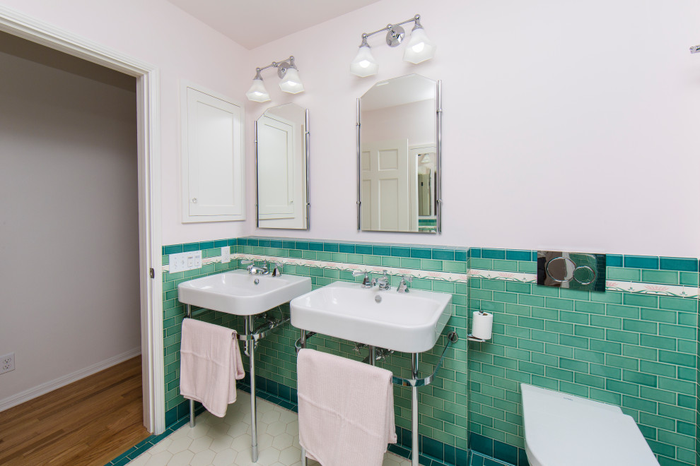 This is an example of a small classic ensuite bathroom in Los Angeles with white cabinets, an alcove shower, a wall mounted toilet, pink tiles, ceramic tiles, ceramic flooring, a pedestal sink, multi-coloured floors and a hinged door.