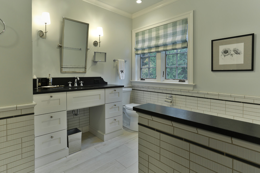 На фото: большая ванная комната в классическом стиле с фасадами с утопленной филенкой, белыми фасадами, душем в нише, черно-белой плиткой, плиткой мозаикой, полом из керамогранита, душевой кабиной, врезной раковиной, столешницей из гранита и серыми стенами с
