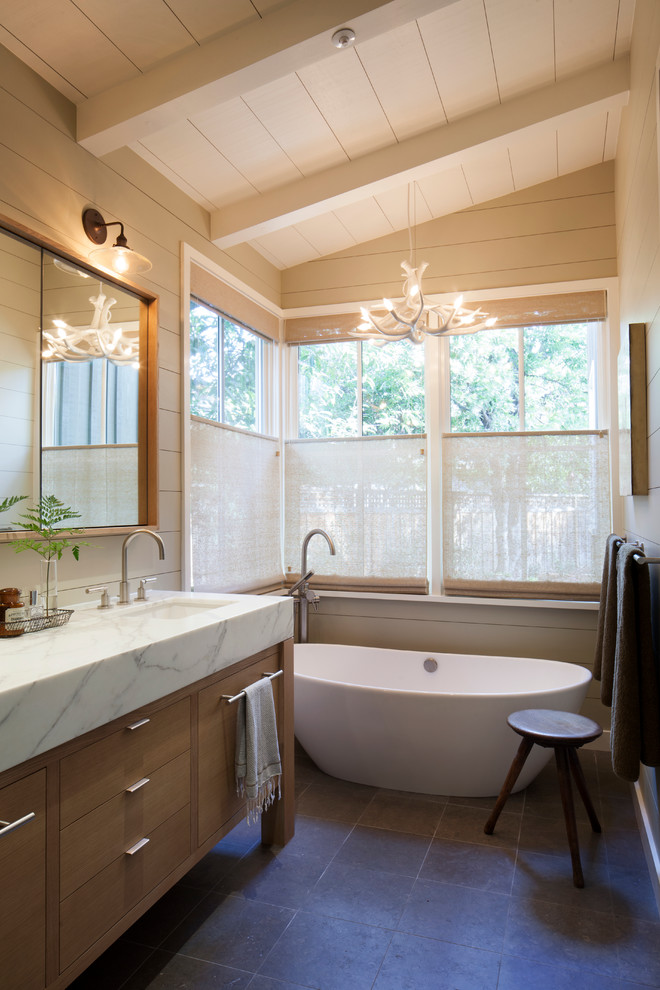 Ispirazione per una stanza da bagno classica con top in marmo, vasca freestanding e pareti beige