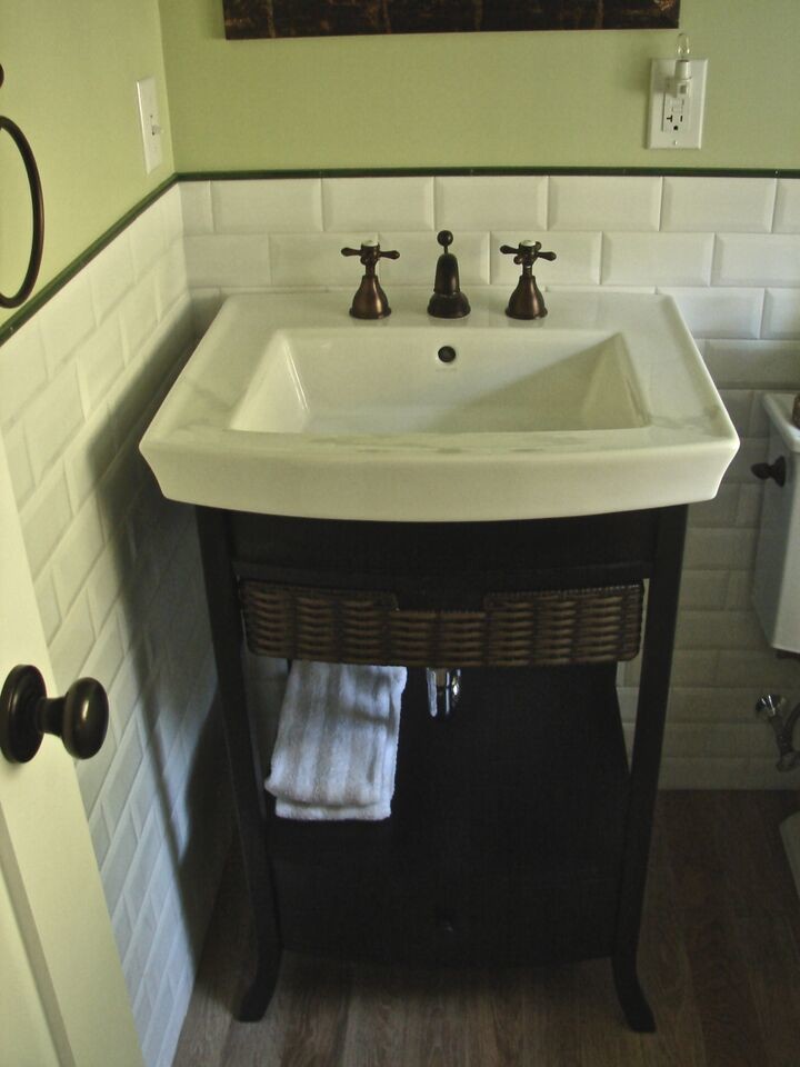 Réalisation d'une petite salle d'eau chalet avec un lavabo de ferme, un mur vert et parquet foncé.