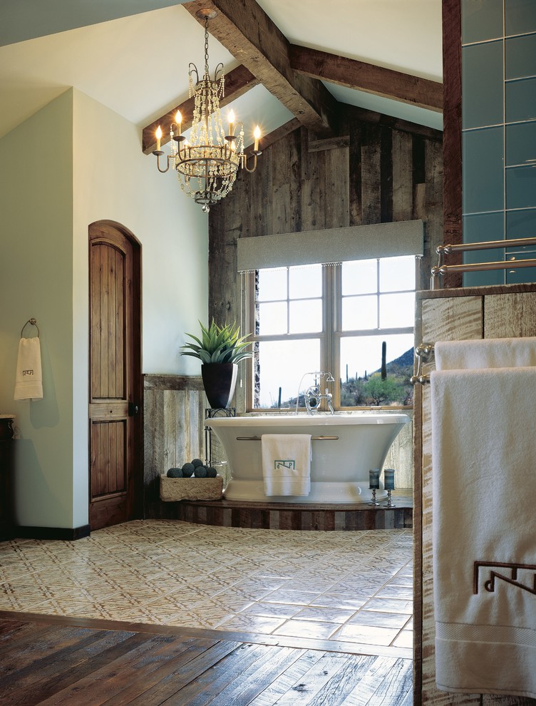 Diseño de cuarto de baño principal de estilo americano grande con bañera exenta, paredes azules, baldosas y/o azulejos verdes, baldosas y/o azulejos de vidrio y suelo de madera oscura