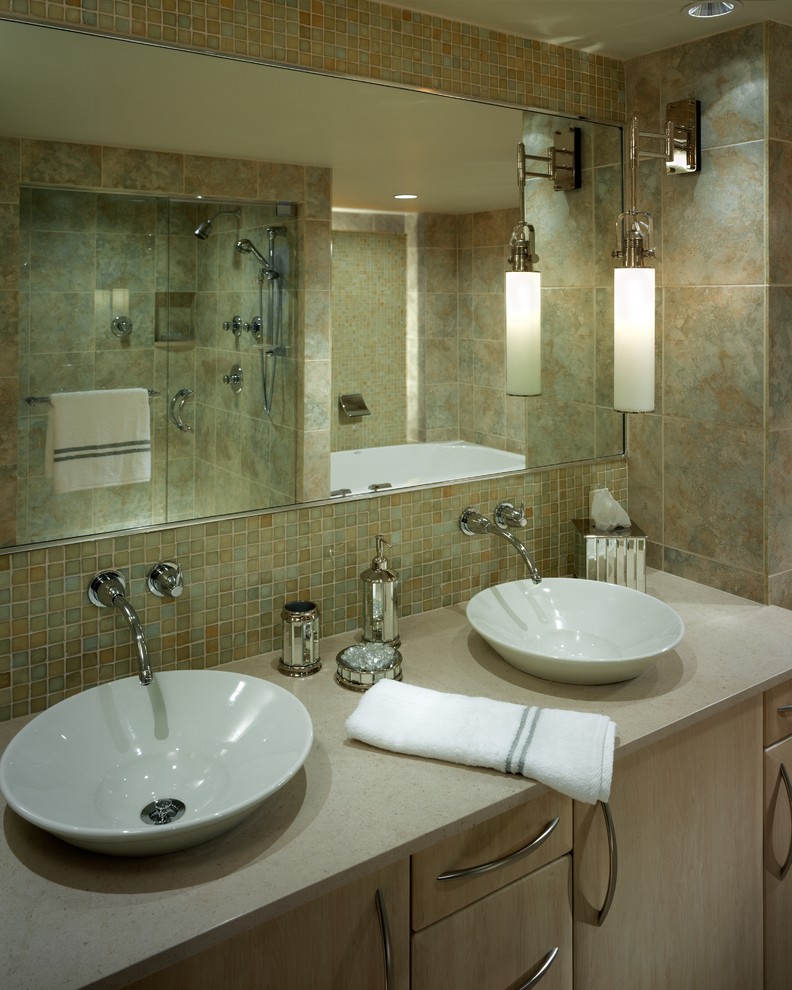 На фото: большая главная ванная комната в современном стиле с светлыми деревянными фасадами, накладной ванной, двойным душем, унитазом-моноблоком, зеленой плиткой, плиткой из листового стекла, полом из известняка, настольной раковиной, столешницей из известняка, плоскими фасадами и зелеными стенами