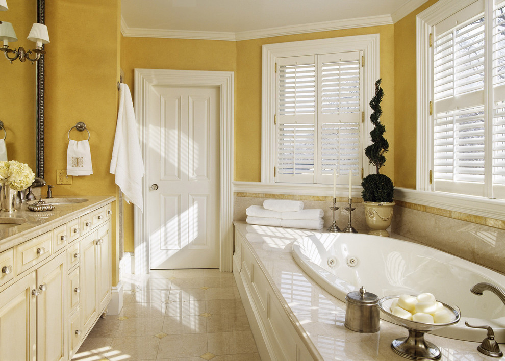 Klassisk inredning av ett badrum, med ett platsbyggt badkar och gula väggar