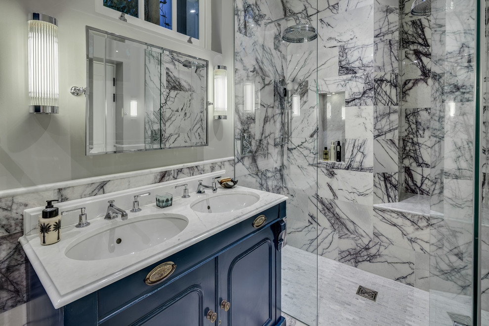Идея дизайна: главная ванная комната среднего размера в стиле неоклассика (современная классика) с накладной раковиной, синими фасадами, мраморной столешницей, отдельно стоящей ванной, двойным душем, раздельным унитазом, разноцветной плиткой, каменной плиткой, серыми стенами и мраморным полом