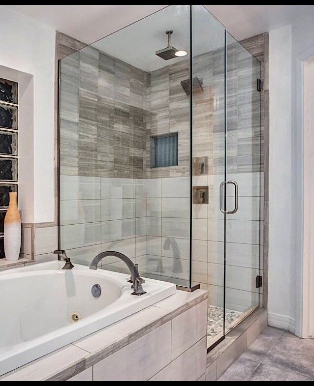 Réalisation d'une salle de bain design avec une baignoire posée, une douche d'angle, un sol gris et une cabine de douche à porte battante.