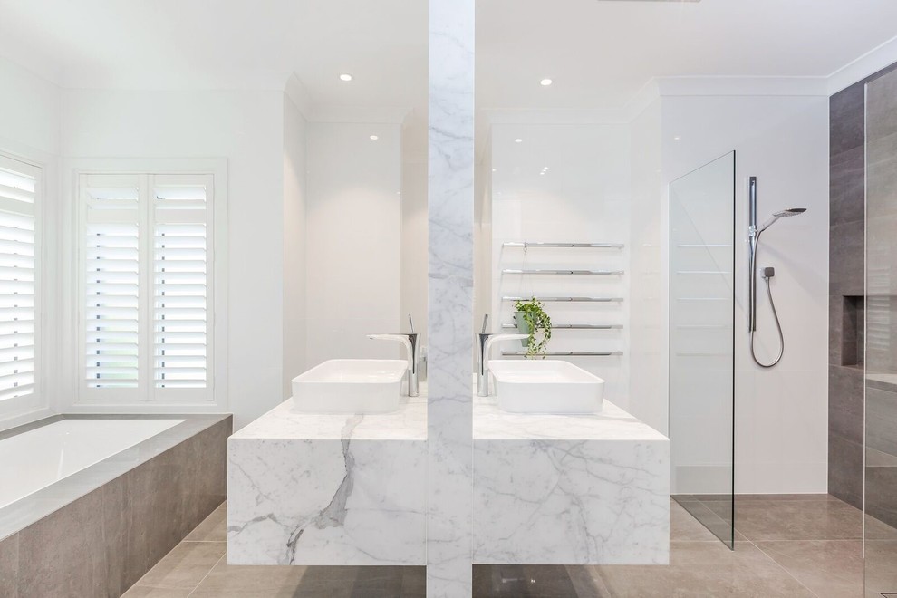Large trendy 3/4 white tile and ceramic tile porcelain tile and brown floor bathroom photo in Adelaide with white walls, marble countertops, flat-panel cabinets, white cabinets, an undermount tub, a one-piece toilet, a vessel sink and white countertops