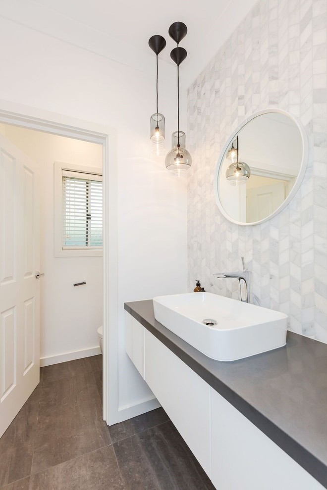 Modern inredning av ett stort grå grått badrum med dusch, med en öppen dusch, vit kakel, keramikplattor, vita väggar, klinkergolv i porslin, brunt golv, med dusch som är öppen, släta luckor, vita skåp, en toalettstol med hel cisternkåpa, ett fristående handfat och bänkskiva i kvartsit