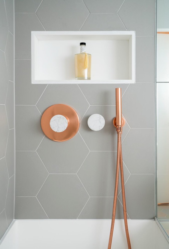Idéer för små funkis badrum, med ett platsbyggt badkar, en dusch/badkar-kombination, en vägghängd toalettstol, grå kakel, grå väggar och flerfärgat golv