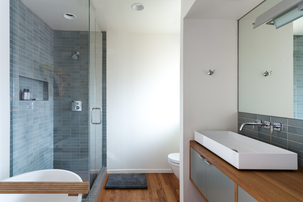 Foto di una stanza da bagno moderna con doccia ad angolo, piastrelle blu e pareti bianche