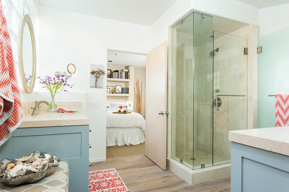 Large beach style kids' beige tile and marble tile light wood floor and gray floor alcove shower photo in Los Angeles with shaker cabinets, blue cabinets, a one-piece toilet, white walls, an undermount sink, marble countertops and a hinged shower door