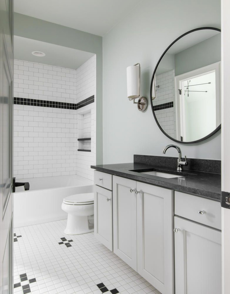 Bathroom - mid-sized transitional white tile and subway tile porcelain tile, white floor and single-sink bathroom idea in Nashville with shaker cabinets, white cabinets, a one-piece toilet, white walls, an undermount sink, granite countertops, black countertops, a built-in vanity and a niche