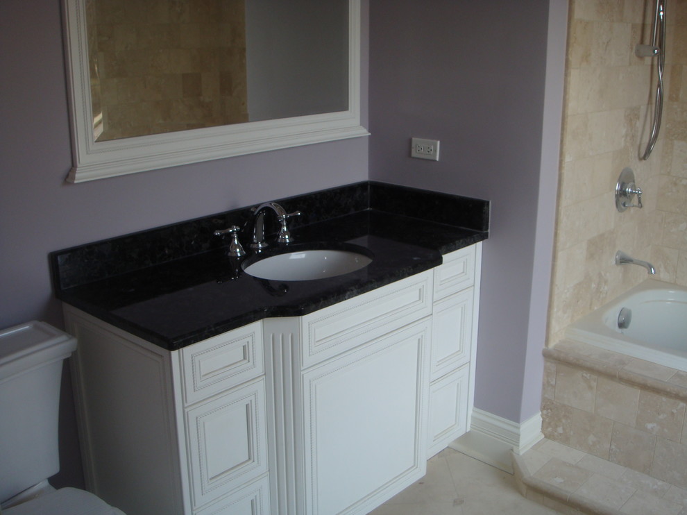 Exemple d'une salle d'eau chic de taille moyenne avec un placard en trompe-l'oeil, des portes de placard blanches, une baignoire posée, un combiné douche/baignoire, WC séparés, un carrelage noir, un mur violet, un sol en travertin, un lavabo encastré et un plan de toilette en quartz modifié.