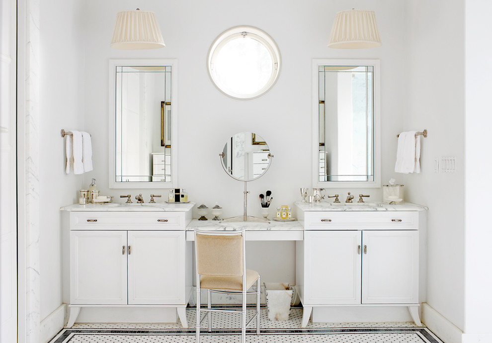 Modelo de cuarto de baño tradicional con lavabo bajoencimera, puertas de armario blancas, encimera de mármol, baldosas y/o azulejos blancos, paredes blancas y armarios con paneles empotrados