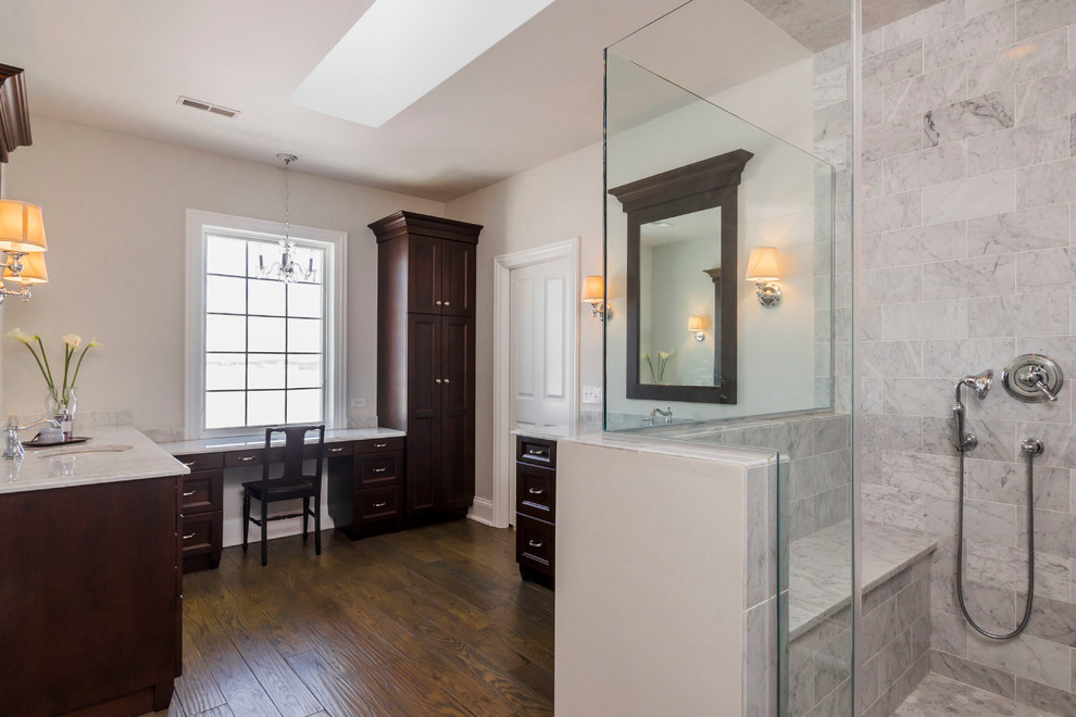 Inspiration for a large classic ensuite bathroom in Chicago with recessed-panel cabinets, dark wood cabinets, a walk-in shower, grey tiles, marble tiles, beige walls, dark hardwood flooring, a submerged sink, marble worktops, brown floors and a hinged door.