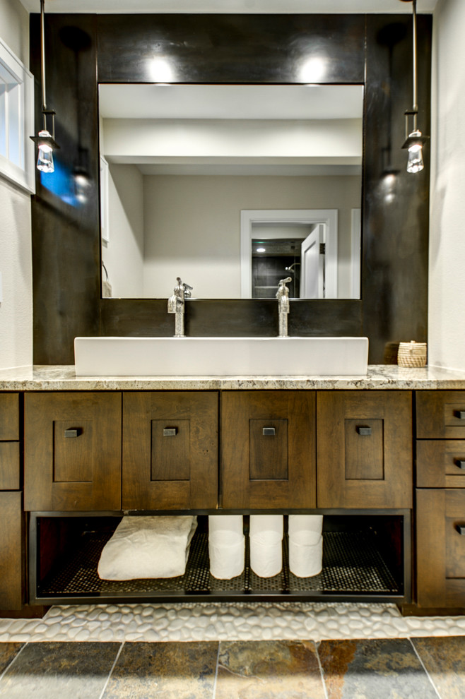 Diseño de cuarto de baño tradicional renovado con lavabo de seno grande, armarios estilo shaker, puertas de armario de madera oscura, encimera de granito, sanitario de dos piezas y suelo de pizarra