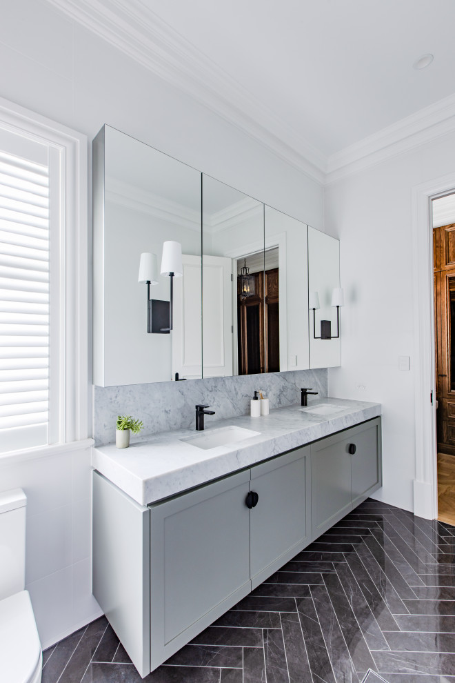 Design ideas for a traditional ensuite bathroom in Adelaide with shaker cabinets, grey cabinets, a double shower, a one-piece toilet, white tiles, porcelain tiles, white walls, marble flooring, a submerged sink, engineered stone worktops, grey floors, a hinged door and white worktops.