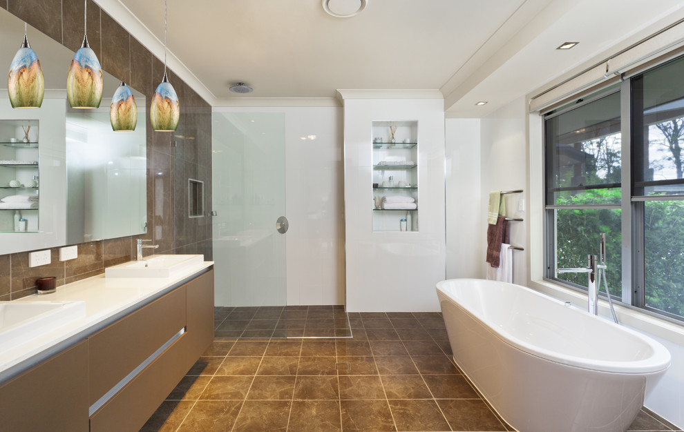 Идея дизайна: ванная комната в современном стиле с плоскими фасадами, коричневыми фасадами, отдельно стоящей ванной, угловым душем, коричневой плиткой, белыми стенами, накладной раковиной, коричневым полом, открытым душем, белой столешницей и зеркалом с подсветкой