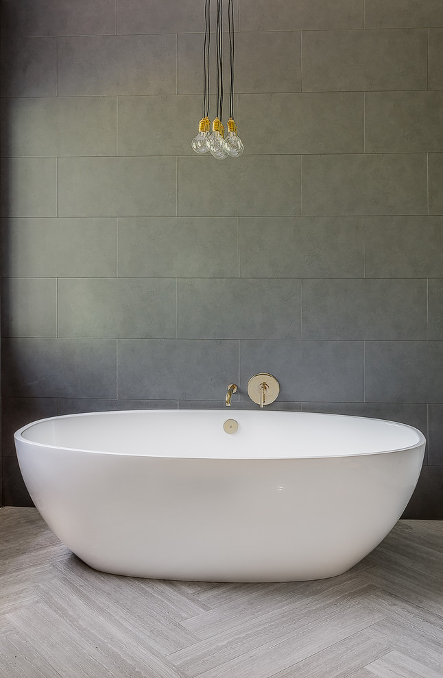 Inspiration for a large contemporary ensuite bathroom in Denver with flat-panel cabinets, medium wood cabinets, a freestanding bath, an alcove shower, a one-piece toilet, grey tiles, porcelain tiles, grey walls, limestone flooring, a submerged sink, engineered stone worktops, grey floors and a hinged door.
