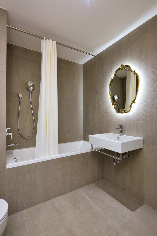 Foto de cuarto de baño actual con lavabo suspendido, bañera empotrada, combinación de ducha y bañera, baldosas y/o azulejos grises y ducha con cortina