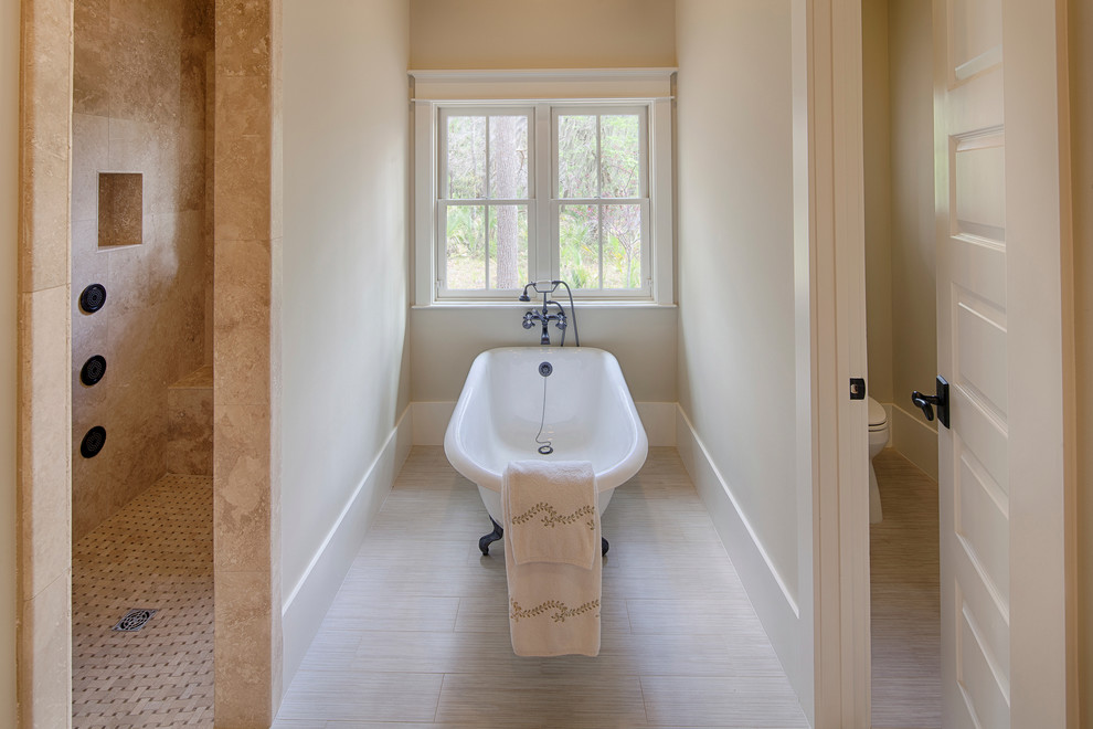 Foto på ett stort vintage en-suite badrum, med luckor med infälld panel, vita skåp, ett badkar med tassar, en kantlös dusch, beige väggar, travertin golv, ett fristående handfat och granitbänkskiva