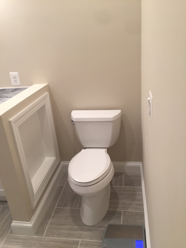 Idées déco pour un WC et toilettes classique de taille moyenne avec un placard à porte shaker, des portes de placard grises, WC séparés, un carrelage gris, un carrelage de pierre, un mur beige, un sol en ardoise, un lavabo encastré et un plan de toilette en marbre.