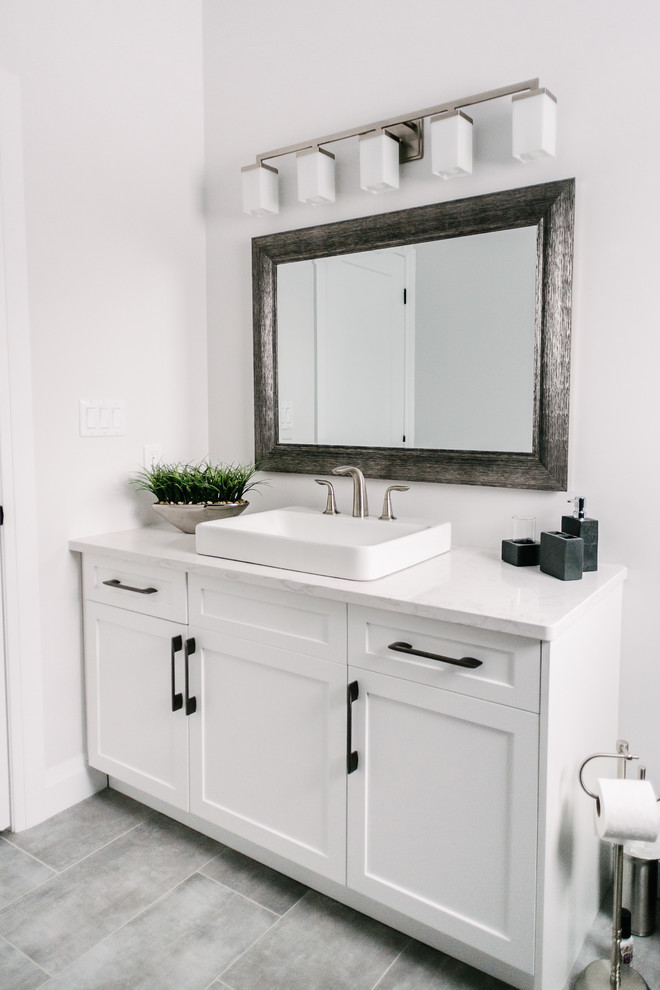 Foto på ett mellanstort funkis vit badrum, med skåp i shakerstil, vita skåp, en dusch i en alkov, en toalettstol med hel cisternkåpa, svart kakel, vita väggar, ett nedsänkt handfat och dusch med gångjärnsdörr