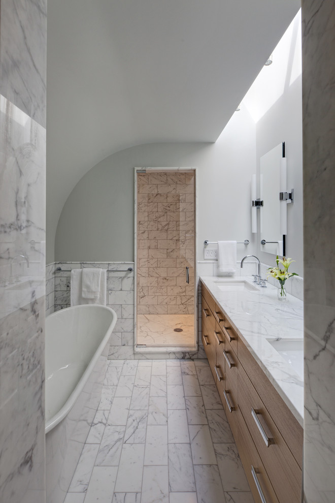 На фото: главная ванная комната среднего размера в современном стиле с плоскими фасадами, светлыми деревянными фасадами, отдельно стоящей ванной, белой плиткой, каменной плиткой, серыми стенами, мраморным полом, врезной раковиной, мраморной столешницей и душем с распашными дверями