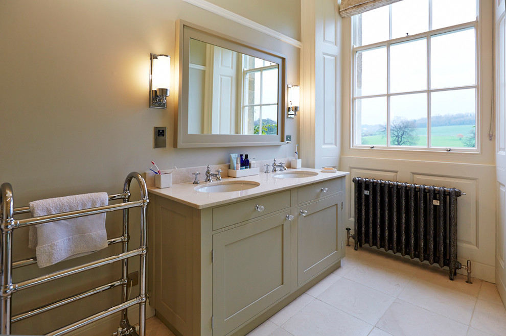 Mittelgroßes Badezimmer mit Einbauwaschbecken, Schrankfronten im Shaker-Stil, grünen Schränken, Marmor-Waschbecken/Waschtisch, beiger Wandfarbe und Kalkstein in Surrey