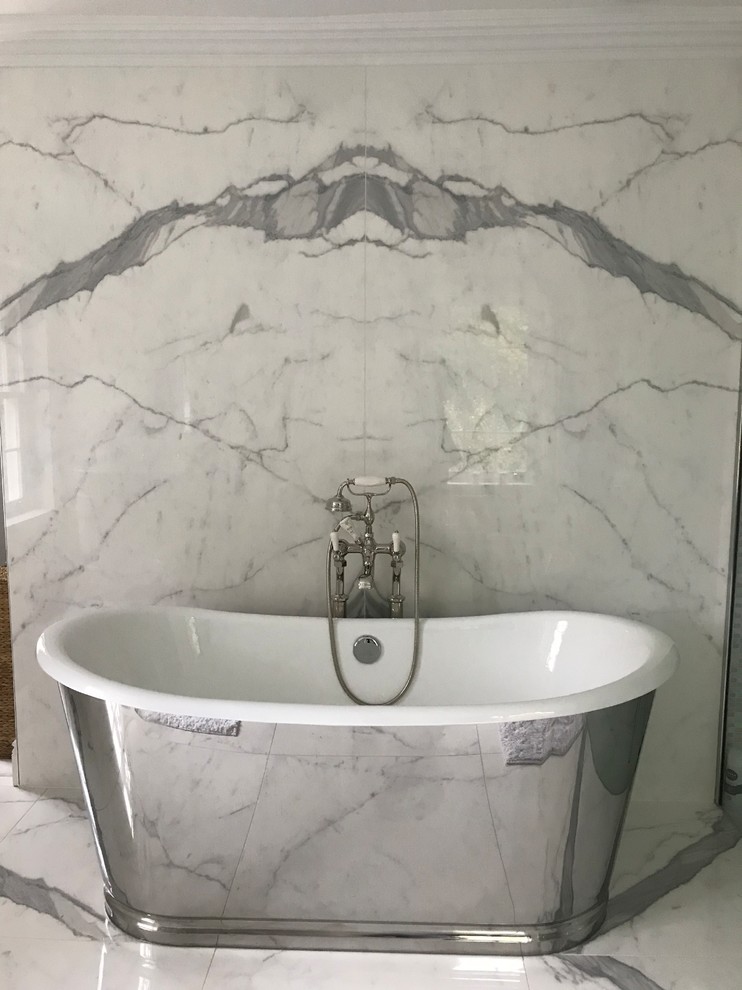 Inspiration for a contemporary bathroom in Other with a freestanding bath, marble flooring and white floors.