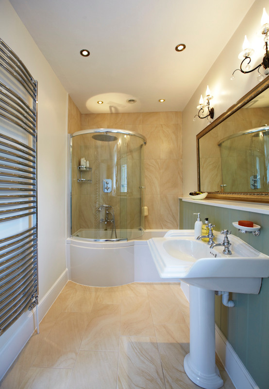 Mittelgroßes Klassisches Badezimmer mit Sockelwaschbecken, Duschbadewanne, beigen Fliesen, Zementfliesen, beiger Wandfarbe und Keramikboden in Sonstige