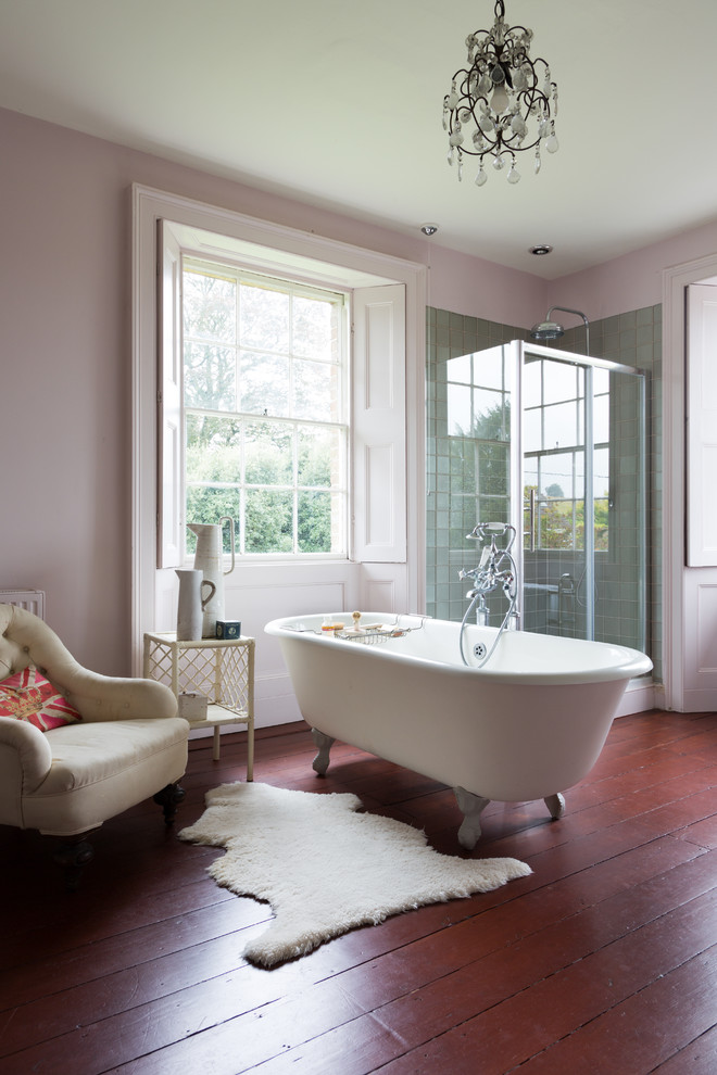Elegant master medium tone wood floor and brown floor freestanding bathtub photo in London with gray walls