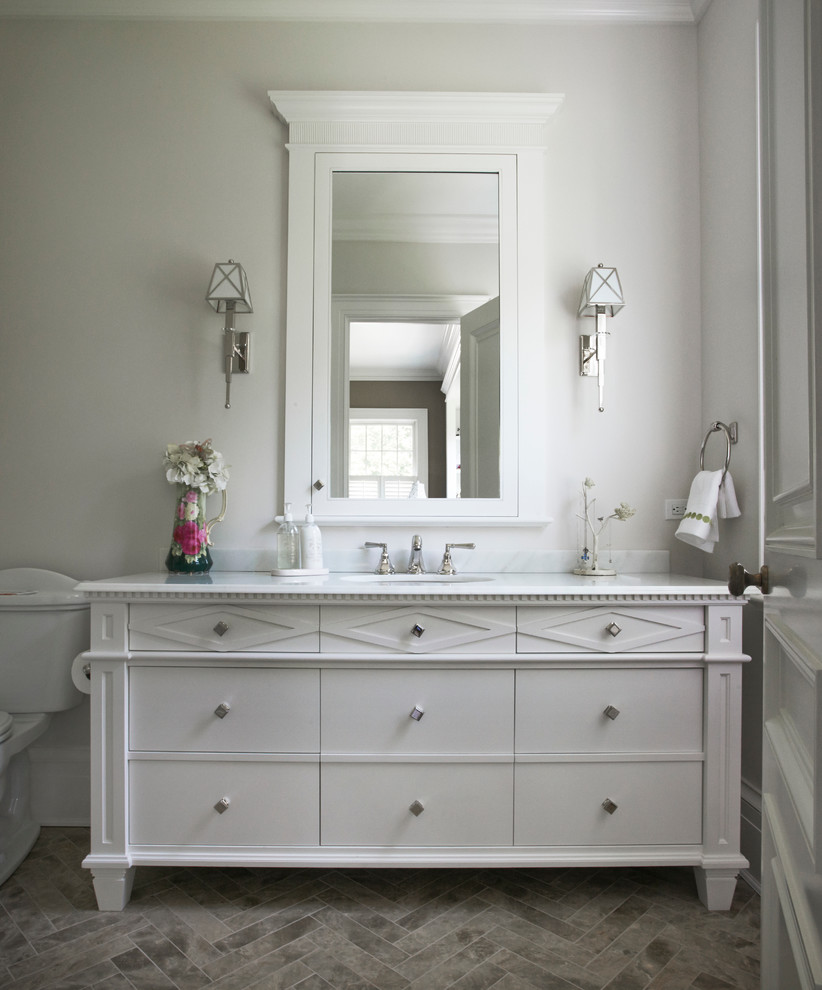 Idéer för att renovera ett mellanstort vintage badrum med dusch, med vita skåp, en toalettstol med separat cisternkåpa, vita väggar, klinkergolv i porslin, ett undermonterad handfat, marmorbänkskiva, beiget golv och släta luckor