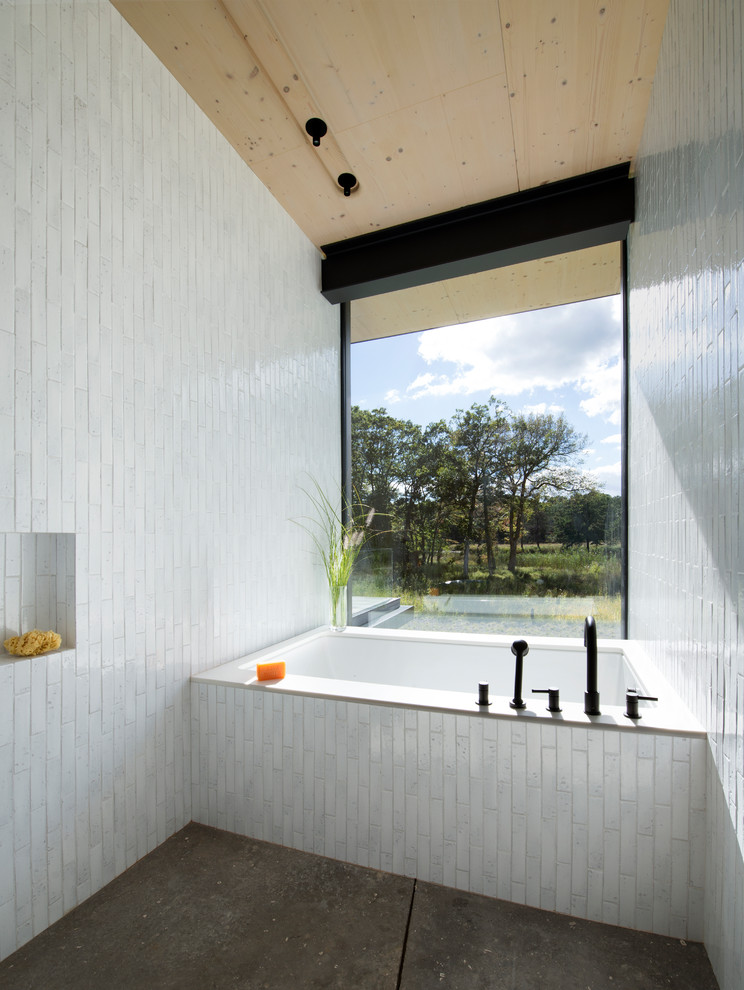 Aménagement d'une salle de bain principale moderne de taille moyenne avec un carrelage blanc, un mur blanc, une baignoire encastrée, un espace douche bain et un sol gris.