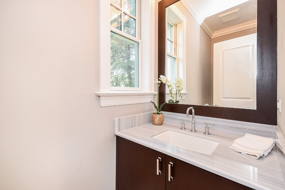 Foto de cuarto de baño clásico renovado de tamaño medio con armarios con paneles lisos, puertas de armario de madera en tonos medios, paredes grises, aseo y ducha, lavabo bajoencimera y encimera de mármol