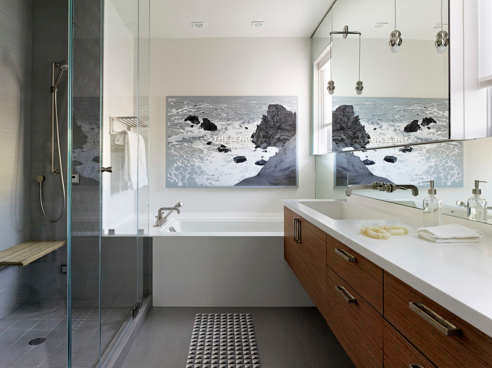 Стильный дизайн: ванная комната в современном стиле с плоскими фасадами, темными деревянными фасадами, полновстраиваемой ванной, душем в нише и серой плиткой - последний тренд