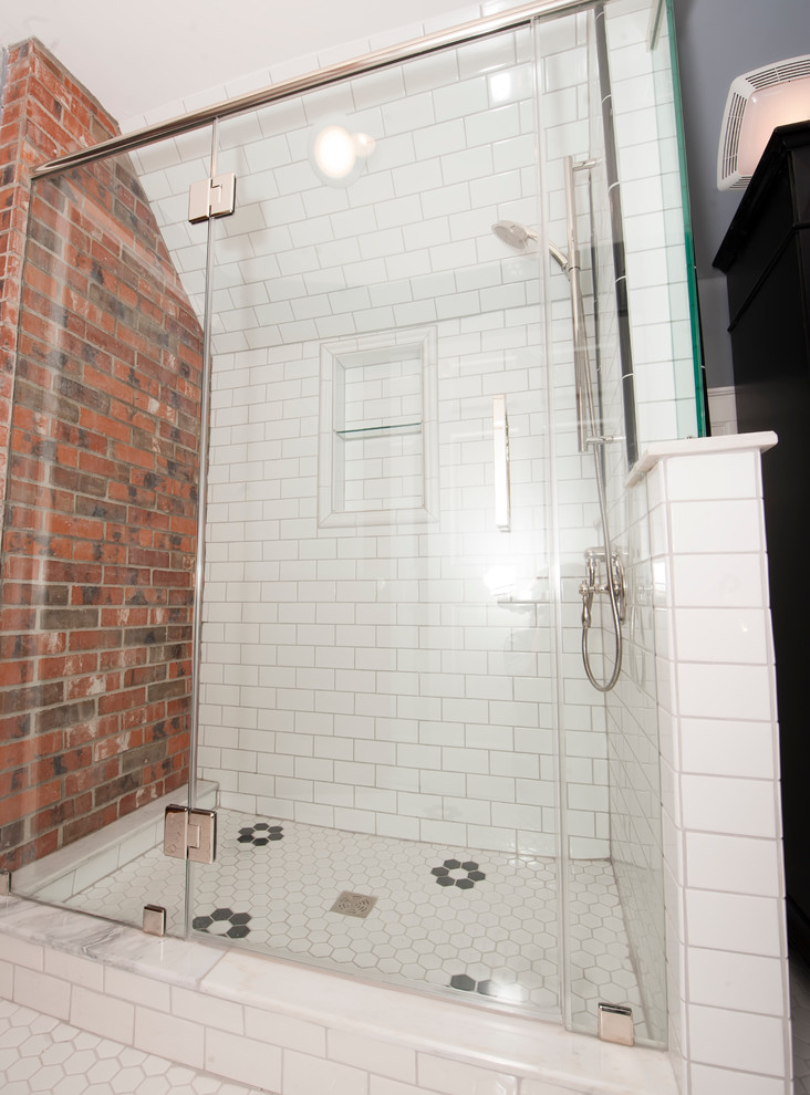 Cette image montre une salle de bain principale design de taille moyenne avec un placard avec porte à panneau encastré, des portes de placard noires, une baignoire indépendante, une douche d'angle, un carrelage blanc, des carreaux de céramique, un mur gris, un sol en carrelage de porcelaine, un lavabo posé et un plan de toilette en marbre.