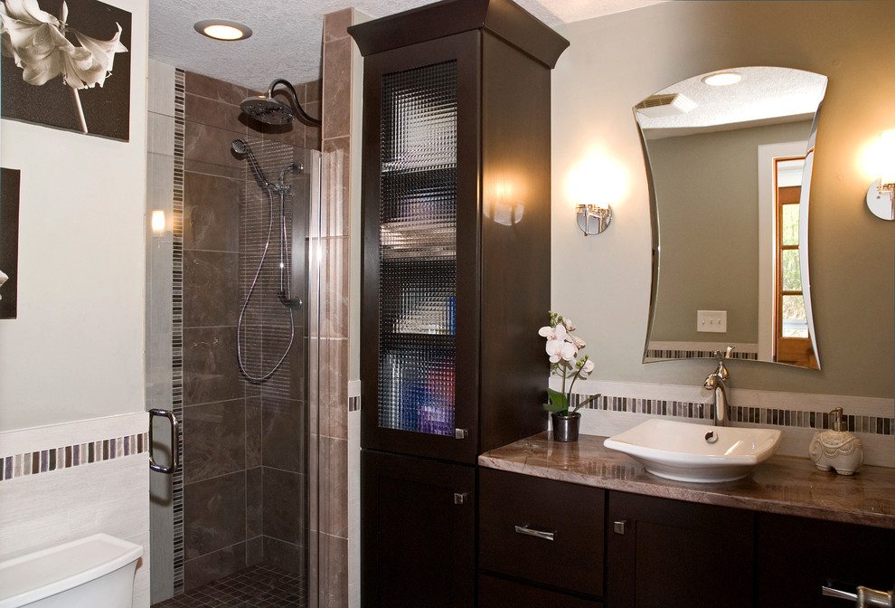 Klassisk inredning av ett litet badrum, med ett fristående handfat, släta luckor, skåp i mörkt trä, marmorbänkskiva, en kantlös dusch, en toalettstol med separat cisternkåpa, porslinskakel, gröna väggar, klinkergolv i porslin och brun kakel