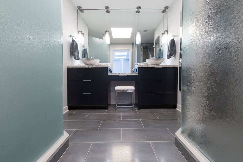 Cette photo montre une salle de bain tendance en bois foncé avec une vasque, un placard à porte plane, un carrelage gris et un mur blanc.