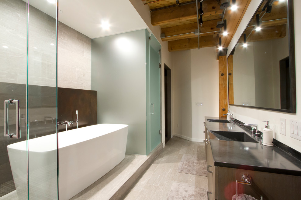 Immagine di una piccola stanza da bagno padronale industriale con vasca freestanding, WC monopezzo, piastrelle grigie, top in cemento, porta doccia a battente e top grigio