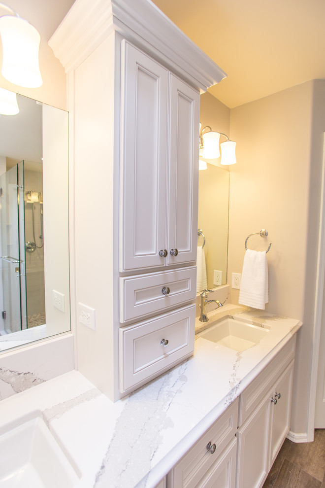 Exempel på ett mellanstort klassiskt vit vitt en-suite badrum, med luckor med profilerade fronter, beige skåp, ett hörnbadkar, en hörndusch, vit kakel, stenhäll, grå väggar, ljust trägolv, ett undermonterad handfat, bänkskiva i kvartsit, grått golv och dusch med gångjärnsdörr