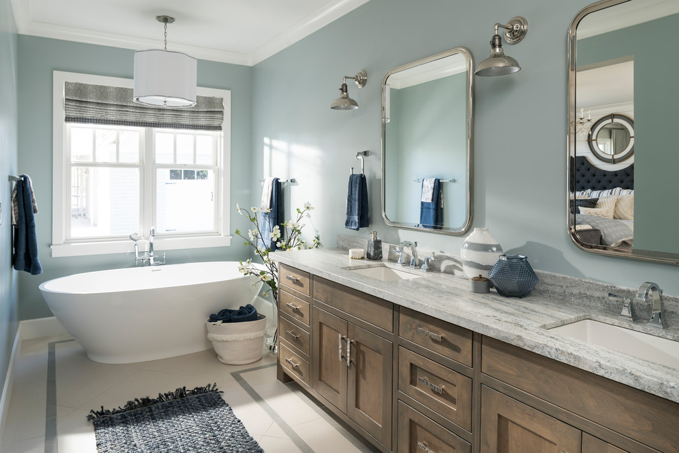 Foto de cuarto de baño campestre con armarios estilo shaker, puertas de armario de madera oscura, bañera exenta, paredes azules, lavabo bajoencimera, suelo blanco y encimeras grises