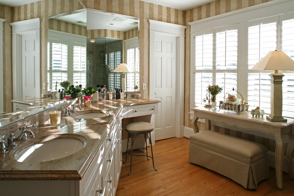 Exempel på ett mellanstort klassiskt en-suite badrum, med marmorbänkskiva, vita skåp, ljust trägolv, ett undermonterad handfat, brunt golv och luckor med infälld panel