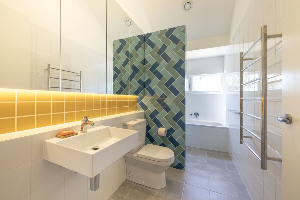 На фото: главная ванная комната среднего размера в современном стиле с стеклянными фасадами, накладной ванной, открытым душем, унитазом-моноблоком, желтой плиткой, керамической плиткой, белыми стенами, полом из керамической плитки, подвесной раковиной, серым полом и открытым душем