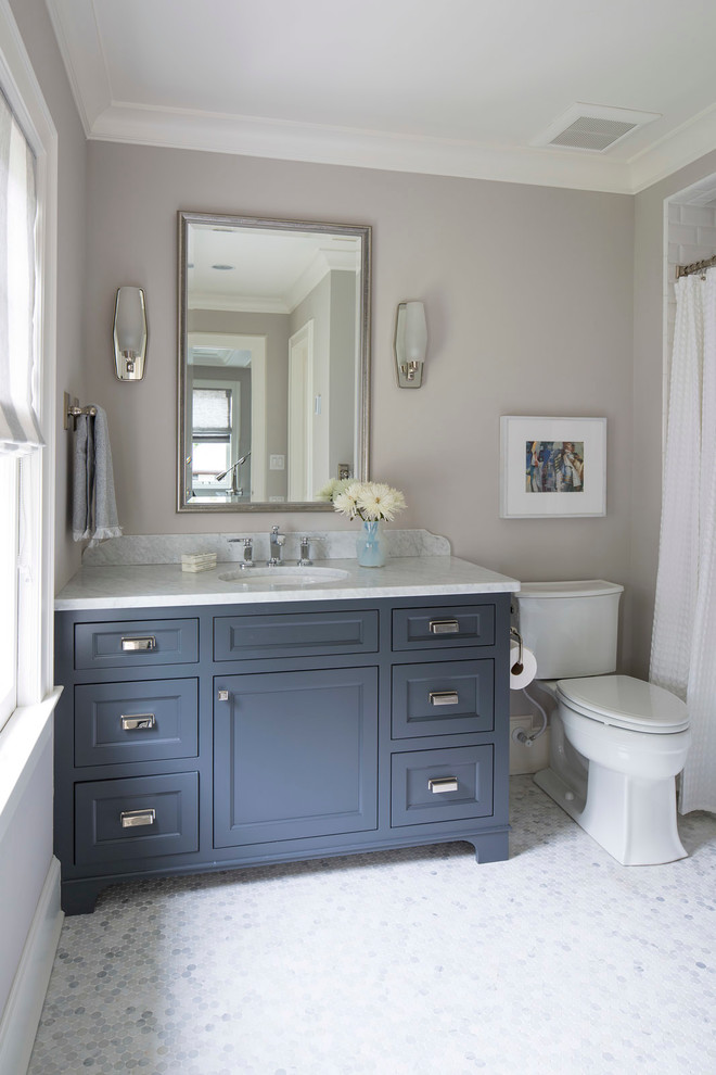 Идея дизайна: ванная комната в классическом стиле с фасадами в стиле шейкер, синими фасадами, ванной в нише, душем над ванной, раздельным унитазом, серыми стенами, врезной раковиной, мраморной столешницей и шторкой для ванной