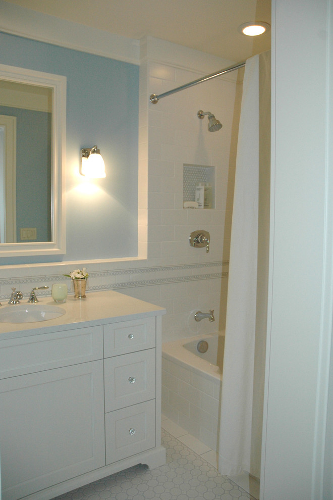 This is an example of a traditional bathroom in Seattle with a submerged sink, freestanding cabinets, white cabinets, quartz worktops, an alcove bath, a shower/bath combination, a one-piece toilet, white tiles, ceramic tiles, blue walls and ceramic flooring.