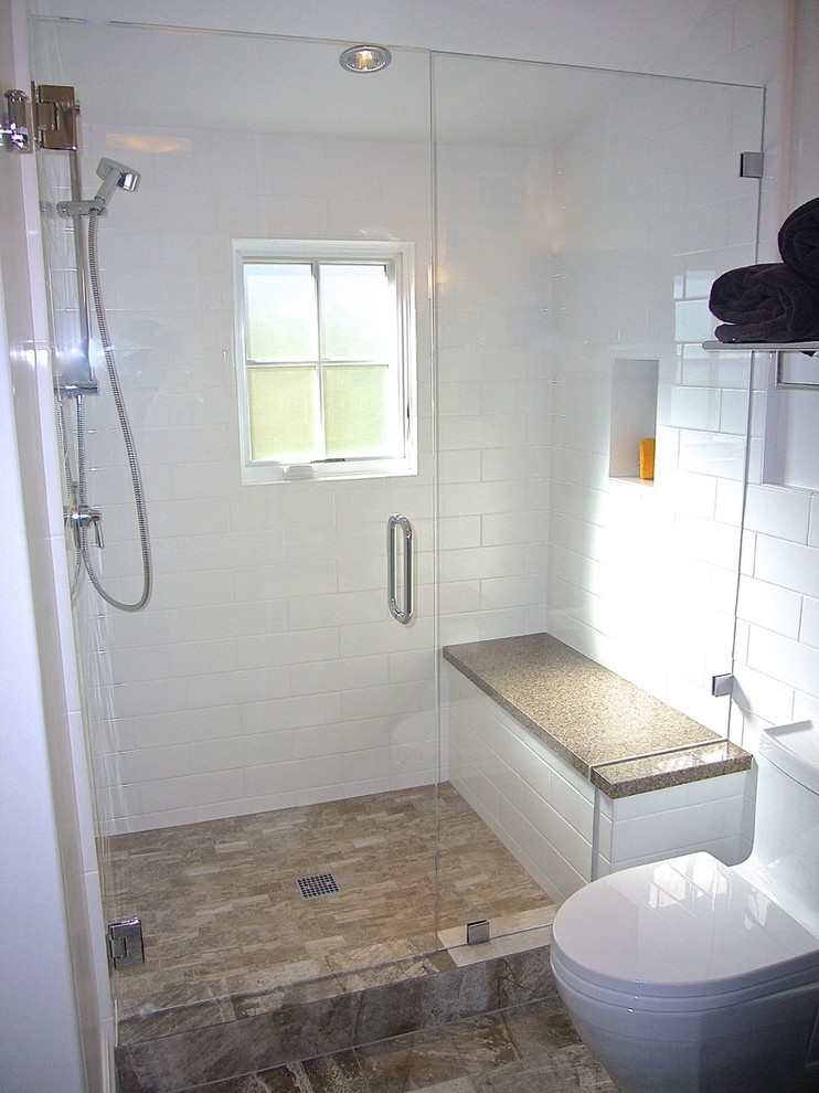 Inredning av ett klassiskt mellanstort badrum med dusch, med ett undermonterad handfat, luckor med profilerade fronter, svarta skåp, bänkskiva i kvarts, en toalettstol med hel cisternkåpa, porslinskakel, vita väggar, klinkergolv i porslin och vit kakel