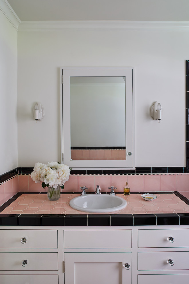 Idéer för att renovera ett vintage rosa rosa badrum med dusch, med vita skåp, vita väggar, ett nedsänkt handfat och kaklad bänkskiva