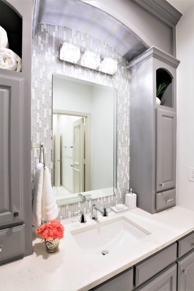 Example of a mid-sized transitional kids' gray tile and mosaic tile marble floor and single-sink alcove shower design in Dallas with gray cabinets, white walls, an undermount sink, quartz countertops, a hinged shower door, white countertops and a built-in vanity