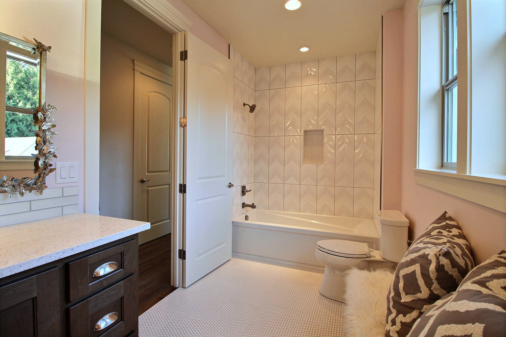 Cette image montre une très grande salle de bain craftsman en bois foncé pour enfant avec un placard avec porte à panneau encastré, un combiné douche/baignoire, WC séparés, un carrelage blanc, des carreaux de céramique, un mur rose, un sol en carrelage de céramique, un lavabo encastré, un plan de toilette en quartz modifié, un sol blanc, une cabine de douche avec un rideau et une baignoire en alcôve.